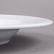 An Arcoroc white porcelain pasta bowl with a rim.