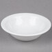 A Tuxton bright white narrow rim china fruit bowl on a white surface.
