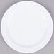 A white Thunder Group Nustone melamine plate with a narrow white rim on a gray surface.
