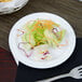 A Thunder Group Nustone white melamine plate with salad and a fork on a table.