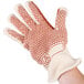 A person wearing a Cordova hot mill glove with a red dot on the palm.