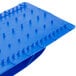 A blue plastic grill cleaning tray with spikes.
