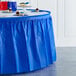A table with a Creative Converting cobalt blue plastic table skirt on it.