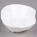 A bright white porcelain small elliptical dish with a hole in the middle.