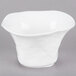 A bright white porcelain bowl with a square base and a small design on it.