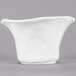 A white 10 Strawberry Street porcelain bowl with a curved edge on a gray surface.