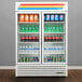 A True refrigerated glass door merchandiser full of soda and soft drinks.