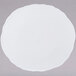 A white oval porcelain platter with a circular spiral design on a white background.
