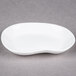 A 10 Strawberry Street bright white elliptical porcelain plate with a curved edge.