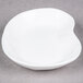 A bright white elliptical porcelain plate with a small hole in the middle.
