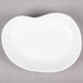 A bright white 10 Strawberry Street elliptical porcelain plate with a small hole in the middle.