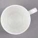 A white Bone China espresso cup and saucer with a handle.