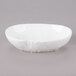 A 10 Strawberry Street bright white porcelain elliptical bowl with a small rim on a gray surface.