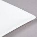 A close-up of a 10 Strawberry Street white square bone china plate with a white rim.