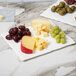 A 10 Strawberry Street bright white rectangular porcelain platter with cheese and grapes.