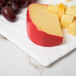 A 10 Strawberry Street bright white rectangular porcelain platter with cheese cubes, grapes, and an apple.