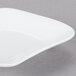 A close-up of a 10 Strawberry Street bright white porcelain plate with a curved edge.