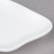 A close up of a 10 Strawberry Street bright white porcelain plate with a curved edge.