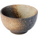 A white stoneware rice bowl with brown speckles.