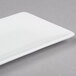 A white rectangular 10 Strawberry Street Izabel Lam Pond bone china plate on a gray surface.