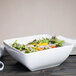 A white 10 Strawberry Street Whittier square porcelain bowl with salad in it.