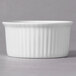 A close up of a 10 Strawberry Street white porcelain fluted ramekin on a gray surface.