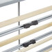 A gray metal rack with wood and metal slats for holding paper rolls.