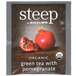 A package of Steep by Bigelow Organic Green Tea with Pomegranate tea bags on a table.