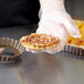 A hand placing a pastry in a Gobel fluted tart pan.