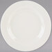 A Tuxton Reno ivory china plate with a wide rim on a gray background.