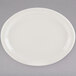 A white Tuxton oval china platter with a narrow rim on a gray surface.