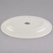 A white Tuxton oval china platter with a wide black rim.