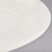 An eggshell white Tuxton oval china platter with a wide rim.