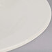 A close up of a Tuxton eggshell china pasta bowl on a white plate.