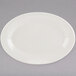 A Tuxton eggshell white china platter with a wide rim on a gray surface.