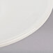 A close up of a Tuxton Reno white saucer with a circular rim.