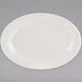 A white Tuxton oval china platter with a rim on a gray surface.