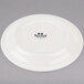A white Tuxton Nevada china plate with black text that reads "Tuxton"