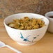 A blue Thunder Group Blue Bamboo melamine rice bowl filled with rice and vegetables on a table.