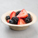 A bowl of strawberries and blackberries in an EcoChoice palm leaf bowl.
