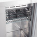 A close-up of an Avantco prep refrigerator with a coated wire shelf inside.