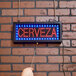 A hand holding an Aarco Cerveza Beer LED sign with red and blue lights.