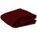 A stack of folded burgundy rectangular Intedge table covers on a white background.