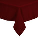 A burgundy rectangular Intedge tablecloth with a white hem on a table.