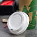A Choice white plastic lid on a paper cup of coffee.