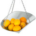 A Cardinal Detecto hanging scale with a metal bowl of oranges on a table.