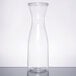 A clear plastic carafe with a clear lid on a table.