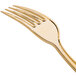 A close up of a Fineline heavy weight plastic fork with a gold handle.