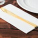 A Fineline gold plastic knife on a napkin.
