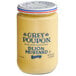 A jar of Grey Poupon Dijon Mustard with blue and yellow label on a white background.